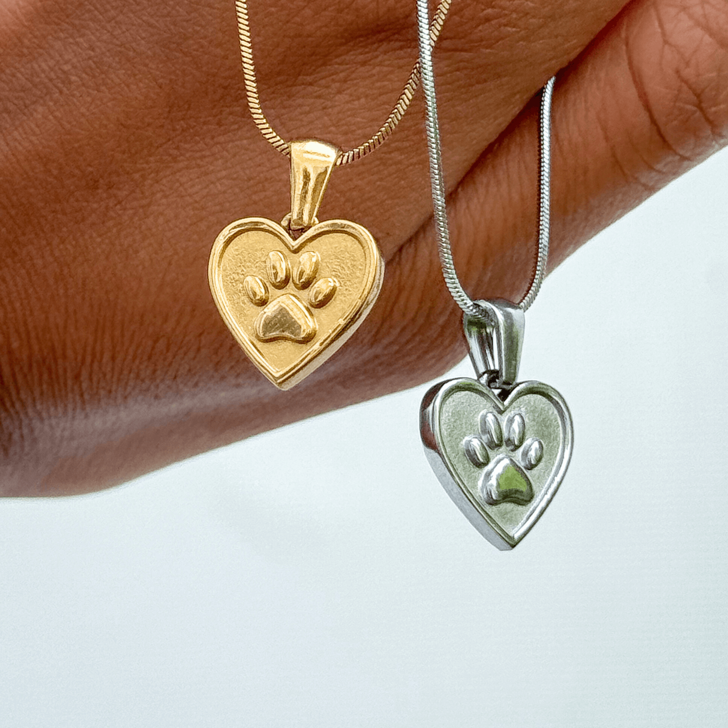 Gold and silver paw and heart dog charity necklaces that help fund 30 shelter dog meals
